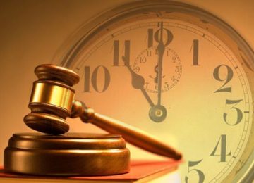 Vintage style wooden gavel from the court placed on a stack of law books on background